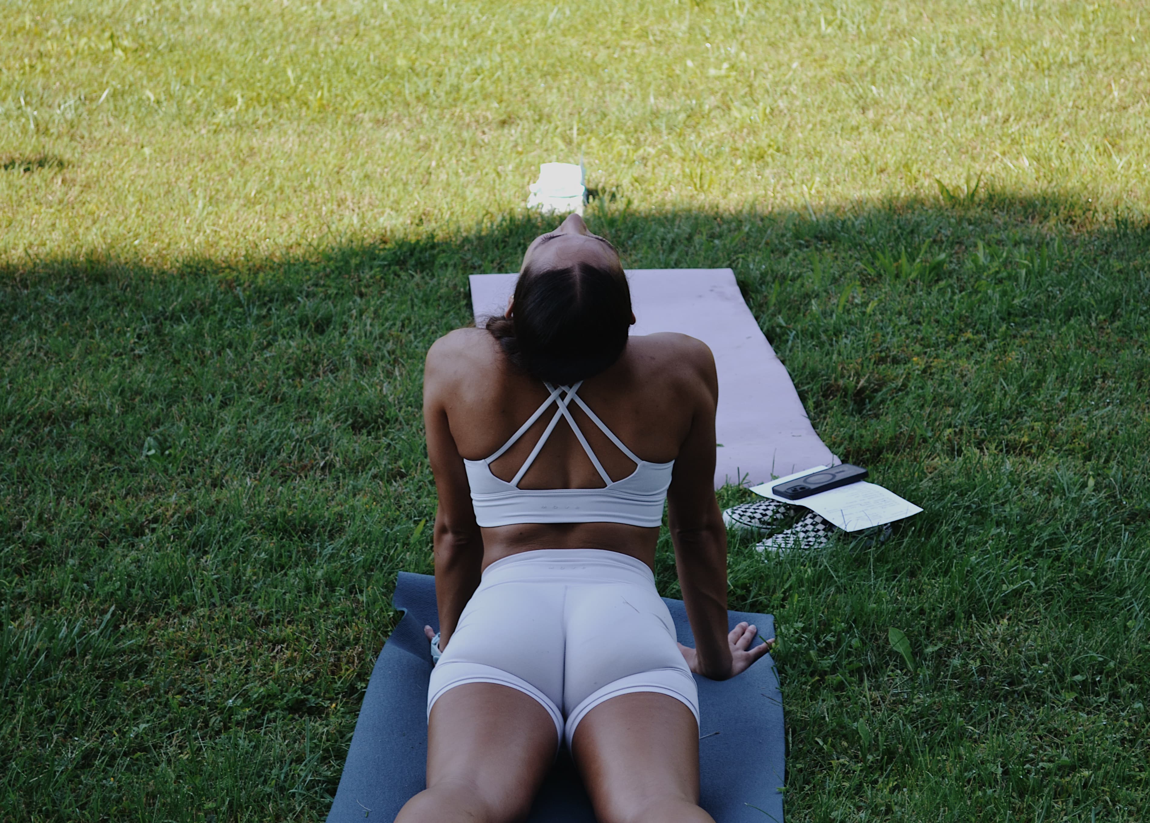 Partecipante di spalle durante una posizione yoga all'aperto