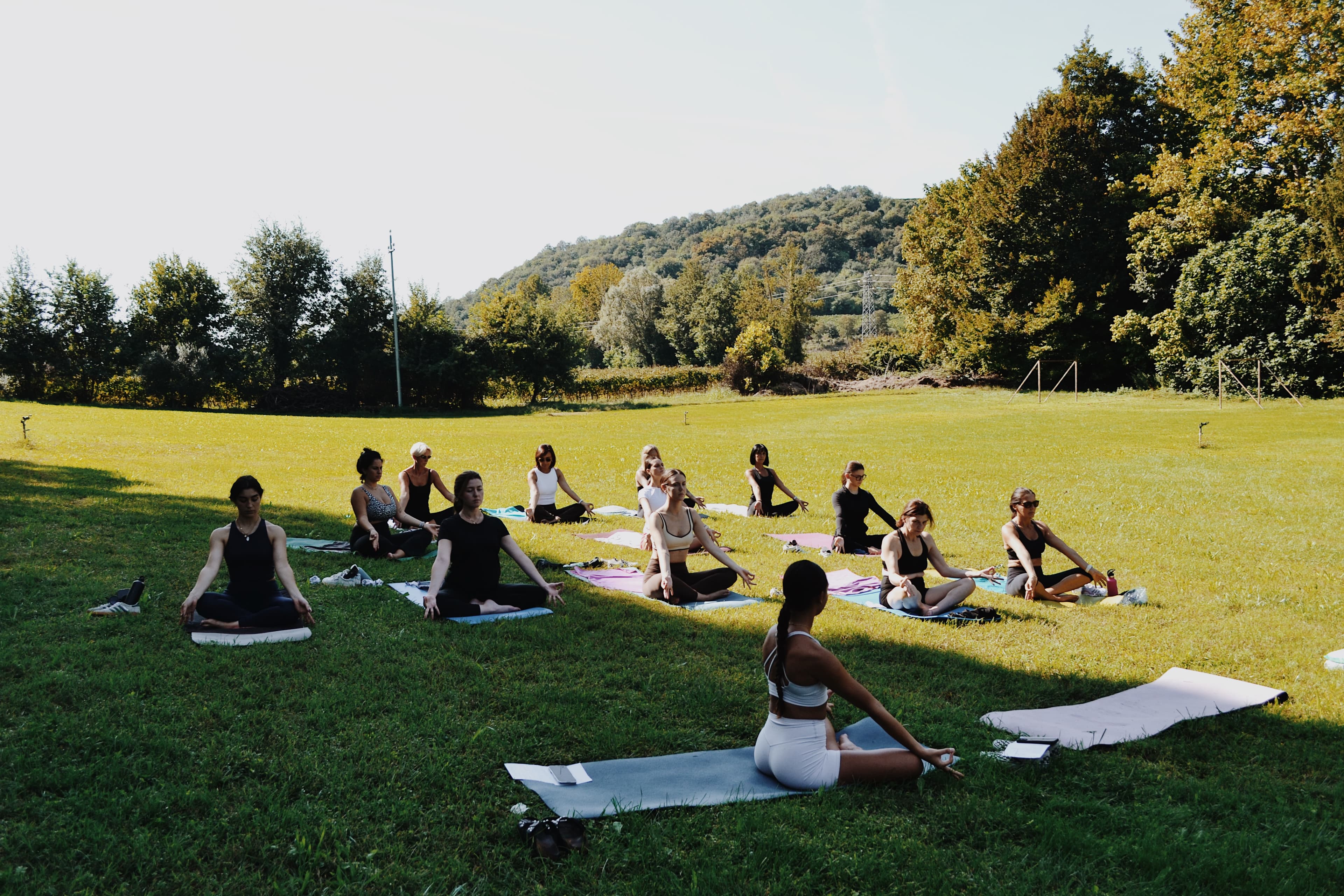 Il gruppo pratica yoga nel giardino durante l'evento Flow & Glow